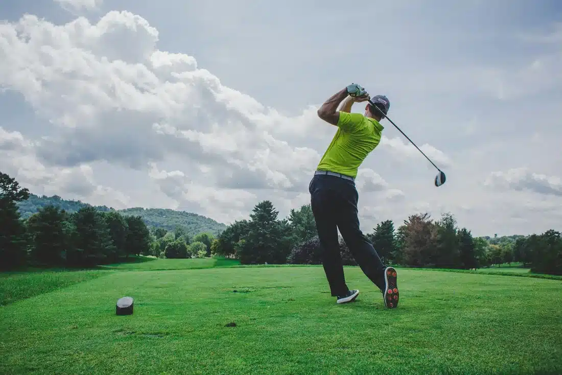 Golfer completing a drive on a golf course