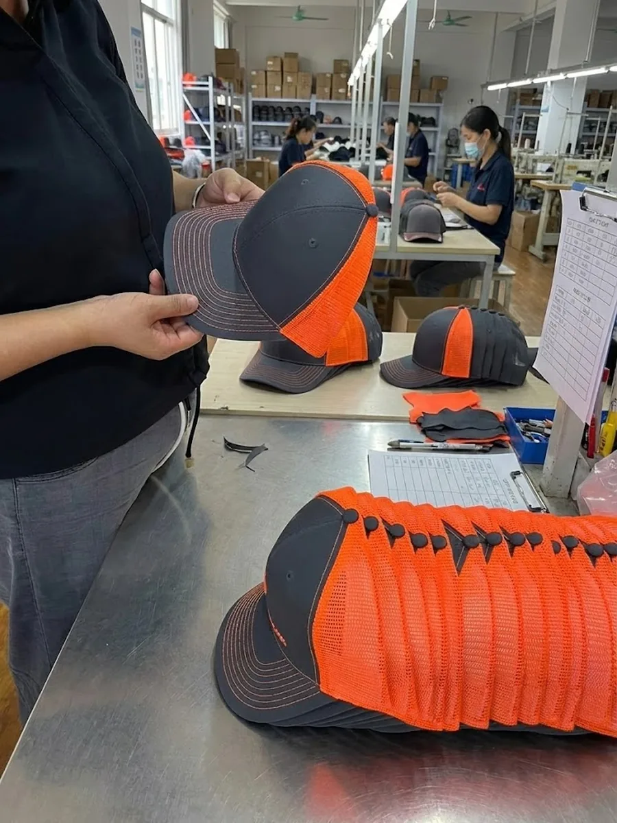 Physical trucker hat samples being checked during production inspection