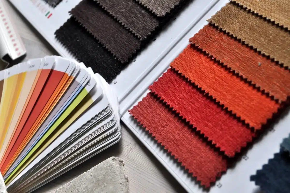Physical fabric swatches and color cards laid out for color comparison