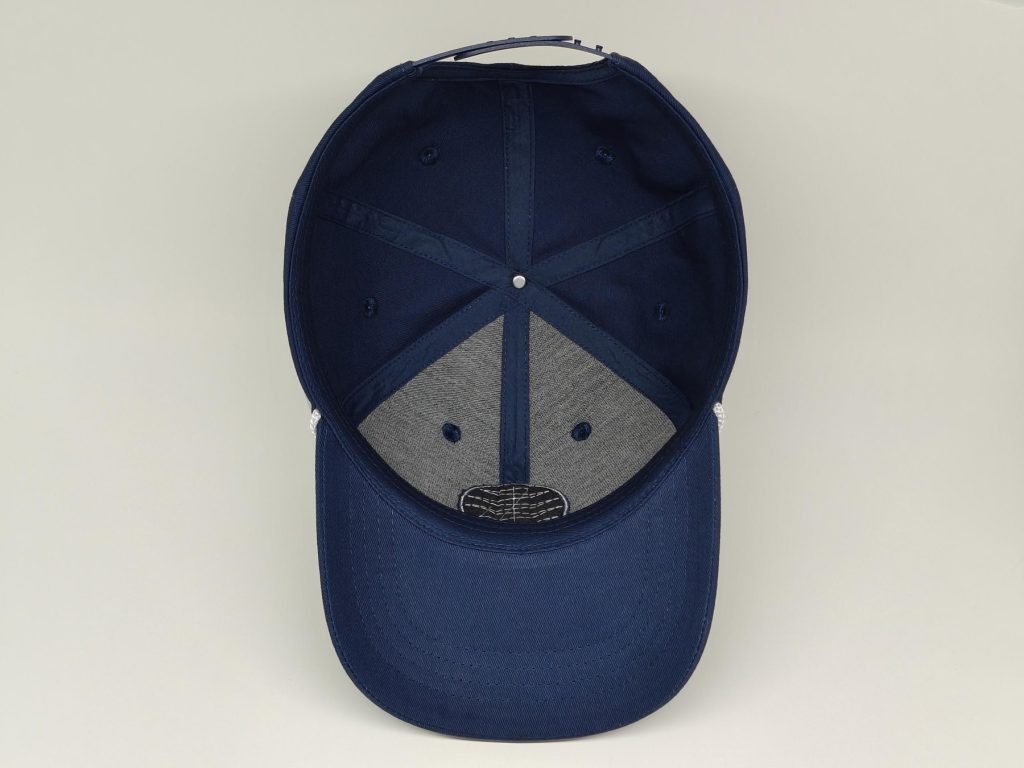 Inside of a navy golf cap showing the sweatband, seams and label area