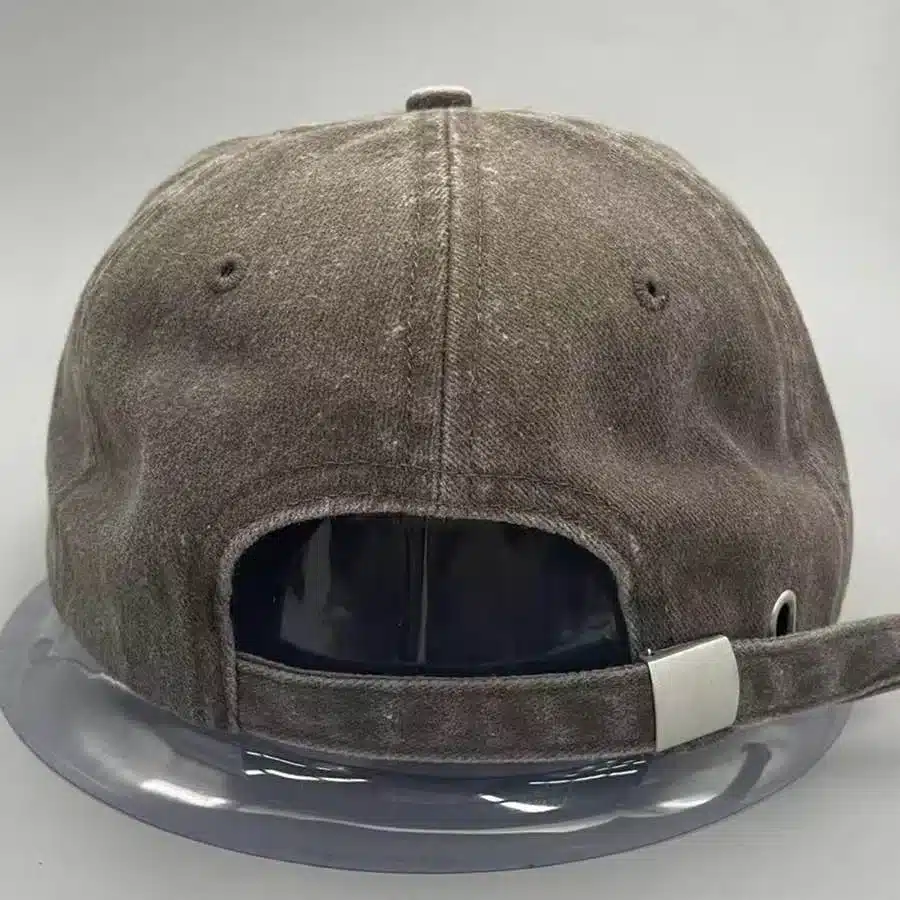 Back view of a washed cotton cap sample showing its faded surface and adjustable closure